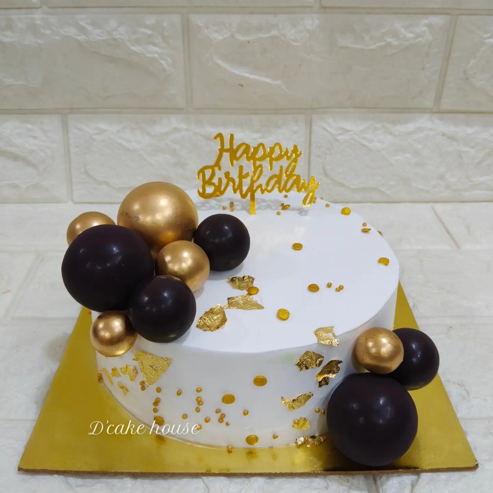 Black and gold cake with glossy spheres